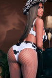 Cheeky big booty sex doll hottie Chantell, seen from the rear, leaning over the arm of the couch, wearing cow-hide themed intimate apparel.