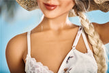 A closeup of Kaja's smile and chest, with one bra cup exposed and the other covered up by her summer dress.