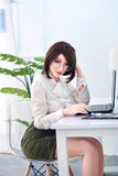 Submissive, flirtatious Mi-Suk, a 159cm sex doll with smooth white skin and dark hair, with big breasts and big booty, seated at her desk with her body facing her computer and her head turned to look at the viewer.