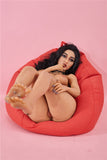 5ft sex doll Dasia, inviting the viewer to suckle her little white toes as she lies naked on a red bean bag.